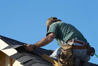 Roofing contractor installs composite tiles